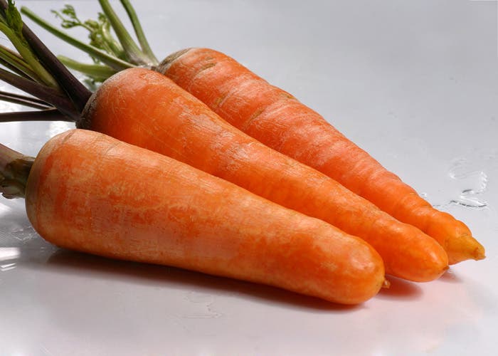 Tres zanahorias sobre fondo blanco